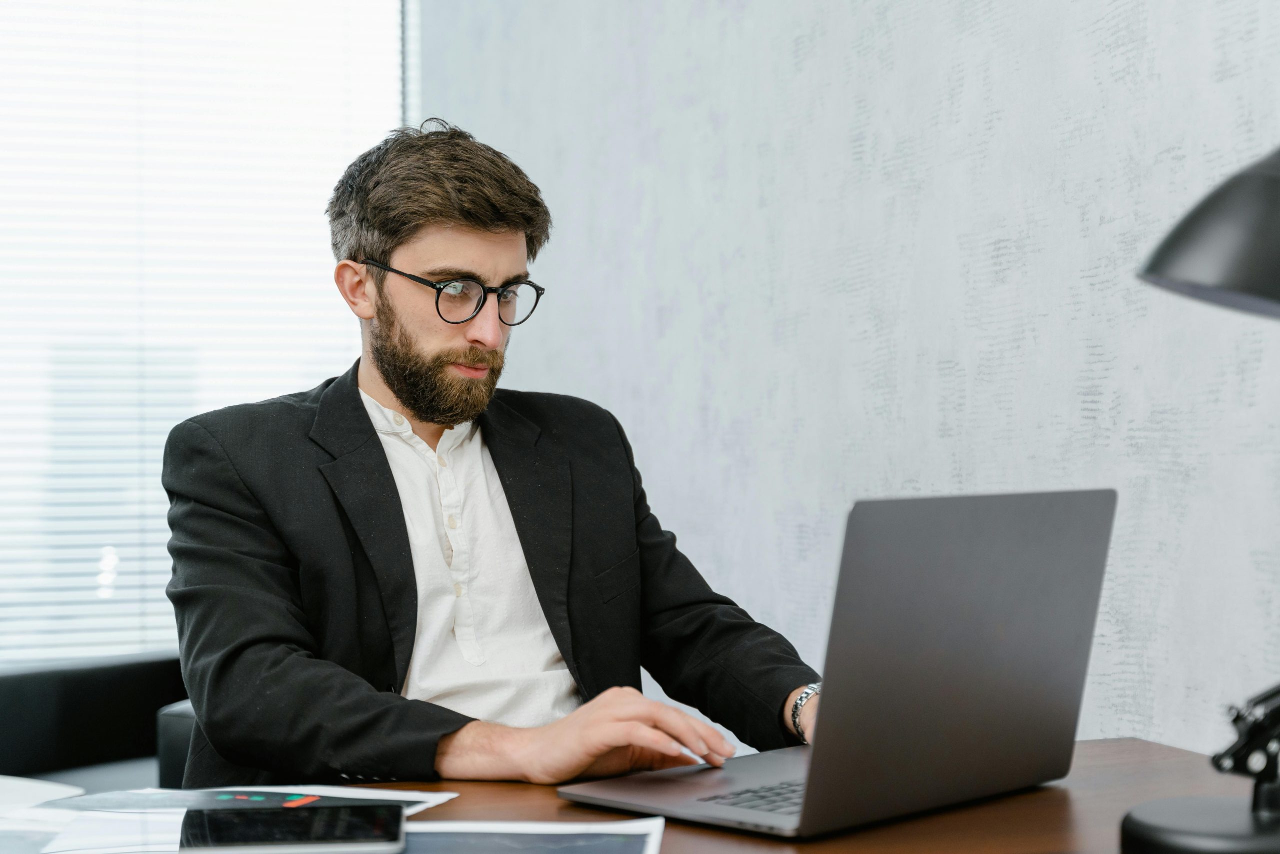 professionally dressed man using a laptop